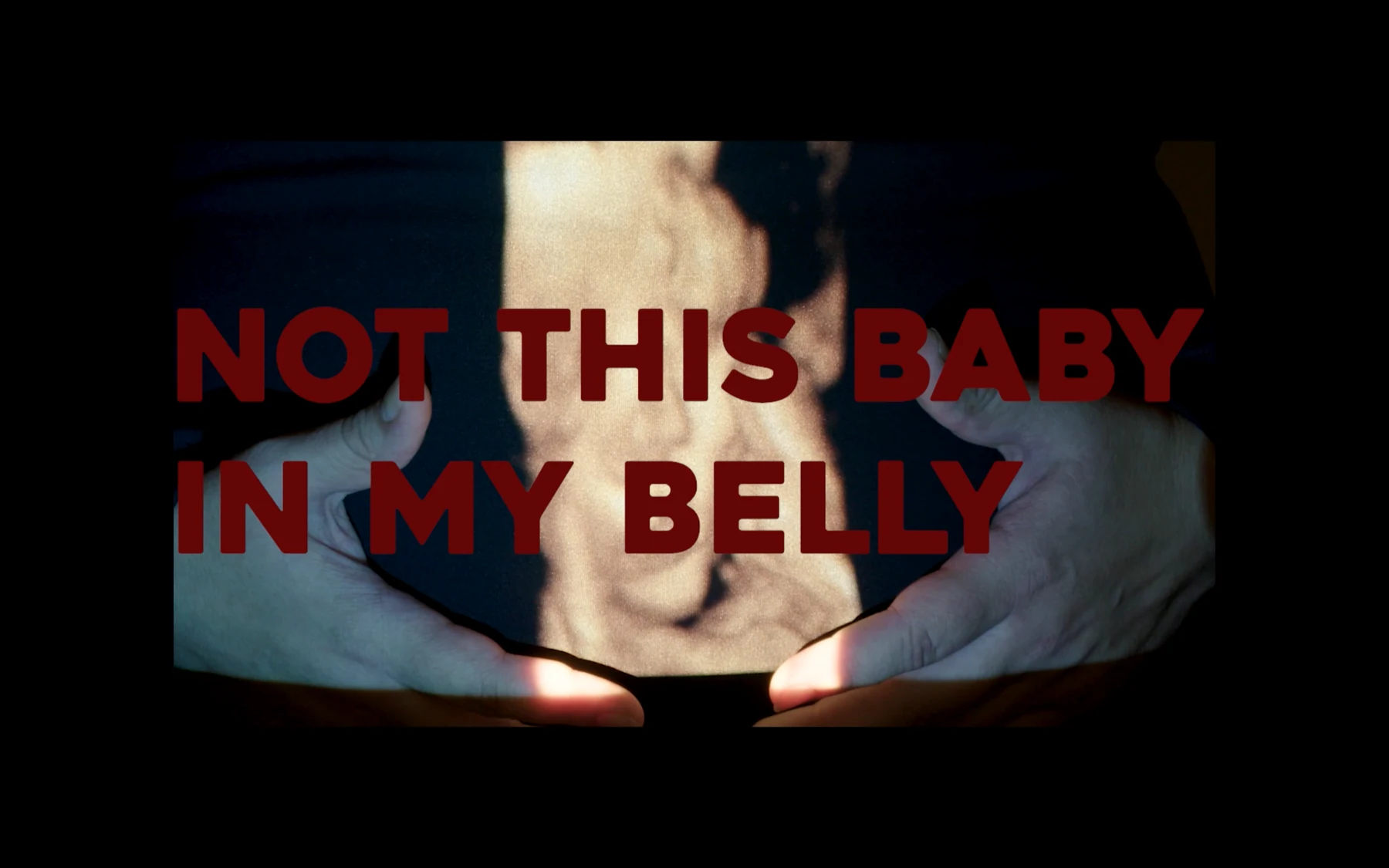 Not This Baby in My Belly, video-installation image with projected ultrasound and the title Not This Baby in My Belly